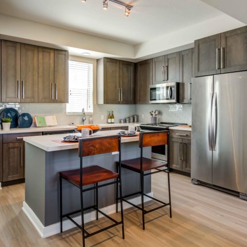 a kitchen with an island and bar stools and a refrigerator