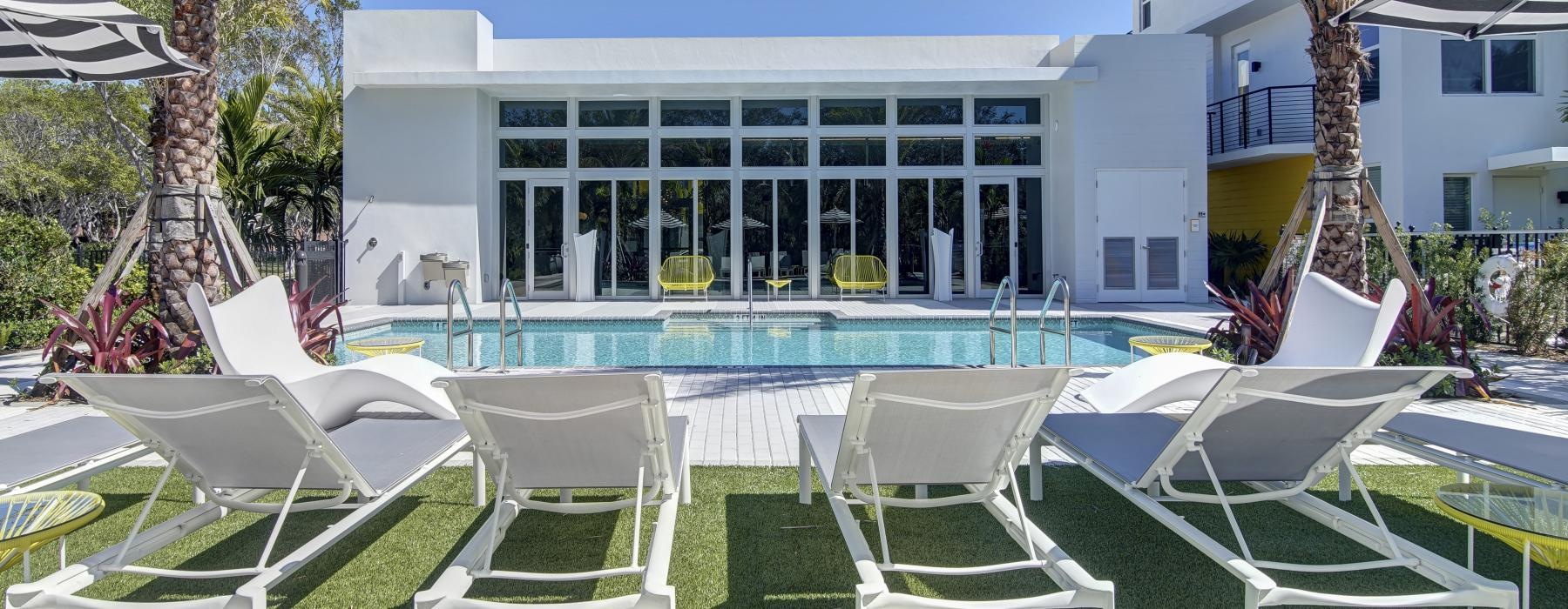 a pool with chairs and umbrellas around it
