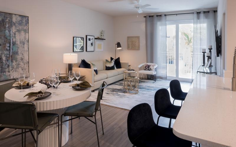 a living room and a dining table and chairs and kitchen island